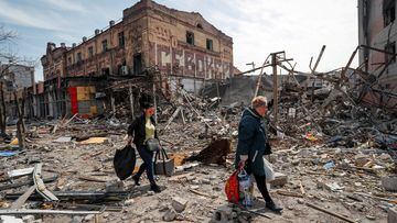 FILE PHOTO: Residents carry their belongings near buildings destroyed in the course of Ukraine-Russia conflict, in the southern port city of Mariupol, Ukraine April 10, 2022. REUTERS/Alexander Ermochenko/File Photo  NO RESALES. NO ARCHIVES
