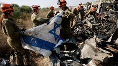 Israeli soldiers from the Home Front Command recover an Israeli flag as they search damaged cars for human remains and other evidence, following the deadly October 7 attack by Hamas gunmen from the Gaza Strip, on a field near Netivot in southern Israel, November 1, 2023. REUTERS/Amir Cohen     TPX IMAGES OF THE DAY