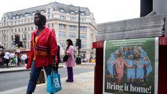 Unos peatones pasan junto a un periódico local londinense que muestra a las "Leonas" del fútbol inglés antes de que jueguen contra España el próximo fin de semana en la final de la Copa del Mundo Femenina, en Londres