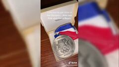Momento en que el nieto muestra la medalla de su abuelo