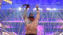 Roman Reigns festeja con el campeonato Universal Unificado de la WWE.