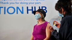 Raquel Bobadilla, 74, is first in line to receive the Covid-19 vaccine administered by Kathryn Acuna, Director of Ambulatory Clinical Services at Kaiser Permanente, on the opening day of a large-scale Covid-19 vaccination site at a parking structure at Ca