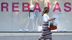 Una mujer pasando delante de una tienda de Zara en rebajas