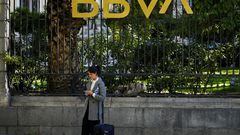 FILE PHOTO: A woman scans through her phone outside a BBVA bank building in Madrid, Spain, November 15, 2021. REUTERS/Juan Medina/File Photo