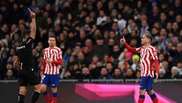 Atletico Madrid's Argentinian forward Angel Correa (R) receives a red card during the Spanish League football match between Real Madrid CF and Club Atletico de Madrid at the Santiago Bernabeu stadium in Madrid, on February 25, 2023. (Photo by OSCAR DEL POZO / AFP)