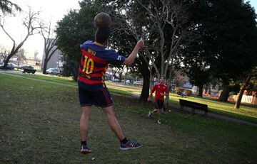 A boy wearing a Barcelona jersey with Lionel Messi's name playing football in a park outside Messi's childhood school in Rosario.