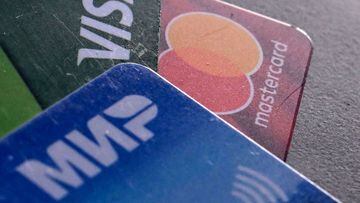 A photo taken on March 14, 2022, shows the logos of Visa, Mastercard and Russian Mir payment systems on bank cards in Moscow.