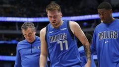 DALLAS, TEXAS - APRIL 10: Luka Doncic #77 of the Dallas Mavericks leaves the court with an injury with Casey Smith and Moses Wright #5 in the second half against the San Antonio Spurs at American Airlines Center on April 10, 2022 in Dallas, Texas. NOTE TO