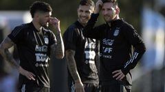 Argentina's forward Lionel Messi (R) gestures next to midfielder Rodrigo de Paul (L) and midfielder Leandro Paredes during a training session in Ezeiza, Buenos Aires on March 23, 2022, ahead of a FIFA World Cup Qatar 2022 qualifier footbal match against Venezuela to be held on March 25. (Photo by JUAN MABROMATA / AFP)