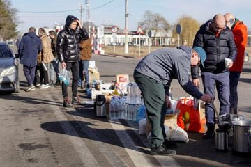 Volunteers hand out tea, water and food to people crossing the border from Ukraine into the Romanian town of Siret.