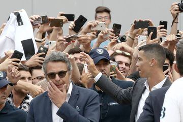 Portuguese attacker Cristiano Ronaldo (R) greets supporters outside the Juventus medical center at the Alliance stadium in Turin on July 16, 2018.