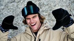 El freeskier Thibault Magnin, equipado con ropa de esquí y con las manos levantadas, sonriendo.