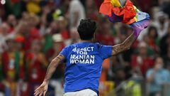 A man wearing a t-shirt reading "Respect For Iranian Woman" runs on the pitch waving a rainbow flag on the pitch during the Qatar 2022 World Cup Group H football match between Portugal and Uruguay at the Lusail Stadium in Lusail, north of Doha on November 28, 2022. (Photo by Pablo PORCIUNCULA / AFP)