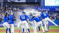 TORONTO, ON - SEPTEMBER 26: Teammates splash Vladimir Guerrero Jr. #27 of the Toronto Blue Jays with water after his walk-off hit to defeat the New York Yankees in the tenth inning during their MLB game at the Rogers Centre on September 26, 2022 in Toronto, Ontario, Canada.   Mark Blinch/Getty Images/AFP