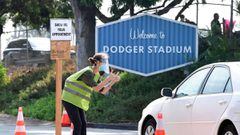 A volunteer wearing facemask and face shield checks for Covid-19 test appointments from motorists arriving at Dodger Stadium in Los Angeles, California. 