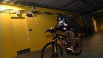 El jugador de los Golden State Warrios Klay Thompson llega a los vestuarios montado sobre una bicicleta.