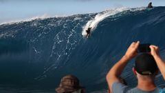Un bodyboarder realiza el drop en una ola gigante en Teahupoo (28 de mayo del 2022), Tahití;, Polinesia Francesa, en la sesion de surf de olas gigantes que marcara una era. Dos personas en un barco se lo miran y graban con el teléfono mientra