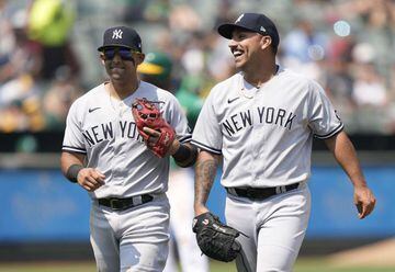 OAKLAND, CALIFORNIA - AUGUST 28: Third baseman Rougned Odor #12 (L) and pitcher Nestor Cortes Jr. #65 (R) of the New York Yankees react after Starling Marte #2 of the Oakland Athletics was doubled off of third base in the bottom of the third inning at Rin