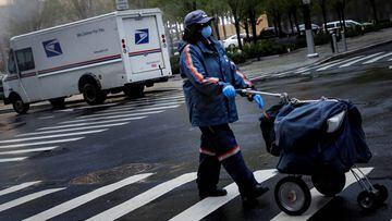 FILE PHOTO: A United States Postal Service (USPS) worker works in the rain in Manhattan during the outbreak of the coronavirus disease (COVID-19) in New York City, New York, U.S., April 13, 2020. REUTERS/Andrew Kelly/File Photo