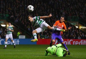 Nir Bitton of Celtic jumps for the ball with David Silva of Manchester City as Craig Gordon of Celtic slides in.