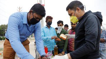 Local residents offer food to migrant workers in Ghaziabad, New Delhi. 