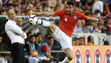 Chile defender Mauricio Isla (4) attempts to keep the ball inbounds as United States head coach Gregg Berhalter, left, watches during the first half of an international friendly soccer match, Tuesday, March 26, 2019, in Houston. (AP Photo/Eric Christian Smith)