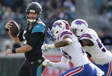 Buffalo Bills defensive end Jerry Hughes (55) and free safety Jordan Poyer (21) chase Jacksonville Jaguars quarterback Blake Bortles (5) out of bounds during the second half in the AFC Wild Card playoff football game at EverBank Field.