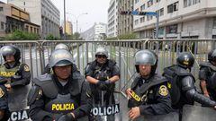Police officers stand guard as supporters of Peruvian President Pedro Castillo gather outside the Congress headquarters in Lima on December 7, 2022. - Peru's President Pedro Castillo dissolved Congress on December 7, 2022, announced a curfew and said he will form an emergency government that will rule by decree, just hours before the legislature was due to debate a motion of impeachment against him. (Photo by Cris BOURONCLE / AFP) (Photo by CRIS BOURONCLE/AFP via Getty Images)