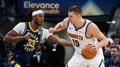 Denver Nuggets center Nikola Jokic (15) dribbles the ball while Indiana Pacers center Myles Turner (33) defends in the first half at Gainbridge Fieldhouse.