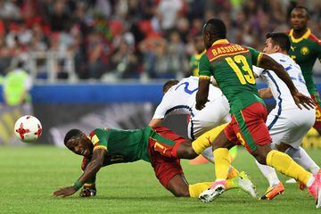 Cameroon's midfielder Arnaud Djoum (L) falls after being challenges by Chile's midfielder Marcelo Diaz (C) and Chile's forward Edson Puch (R) during the 2017 Confederations Cup group B football match between Cameroon and Chile at the Spartak Stadium in Moscow on June 18, 2017. / AFP PHOTO / Yuri KADOBNOV