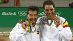 Marc López y Rafa Nadal muerden la medalla de oro lograda en la modalidad de dobles en los Juegos Olímpicos de Río.