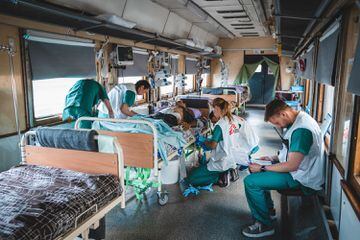 El equipo médico dentro de la unidad de cuidados intensivos (UCI) del tren médico de MSF monitorea y estabiliza a un paciente gravemente herido de guerra durante el viaje desde Pokrovsk, en el este de Ucrania, hasta Lviv, en el oeste de Ucrania, en un viaje que dura 20 horas.