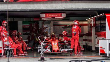 Team members of Ferrari&#039;s Finland driver Kimi Raikkonen sit inside the team garage after retiring from the race during the Formula One Malaysia Grand Prix in Sepang on October 1, 2017. / AFP PHOTO / POOL / AHMAD YUSNI