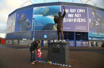 People place a Southampton scarf alongside bunches of daffodils and Cardiff City scarves at the foot of the statue of Fred Keenor, outside Cardiff City's football stadium in Cardiff, south Wales on January 22, 2019, after news of the disappearance of the 