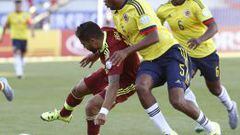 El centrocampista colombiano Edwin Valencia (c) lucha el bal&oacute;n con el centrocampista venezolano Ronald Vargas (i).