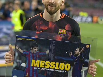 Messi con el cuadro conmemorativo de sus 100 goles en la Champions League.