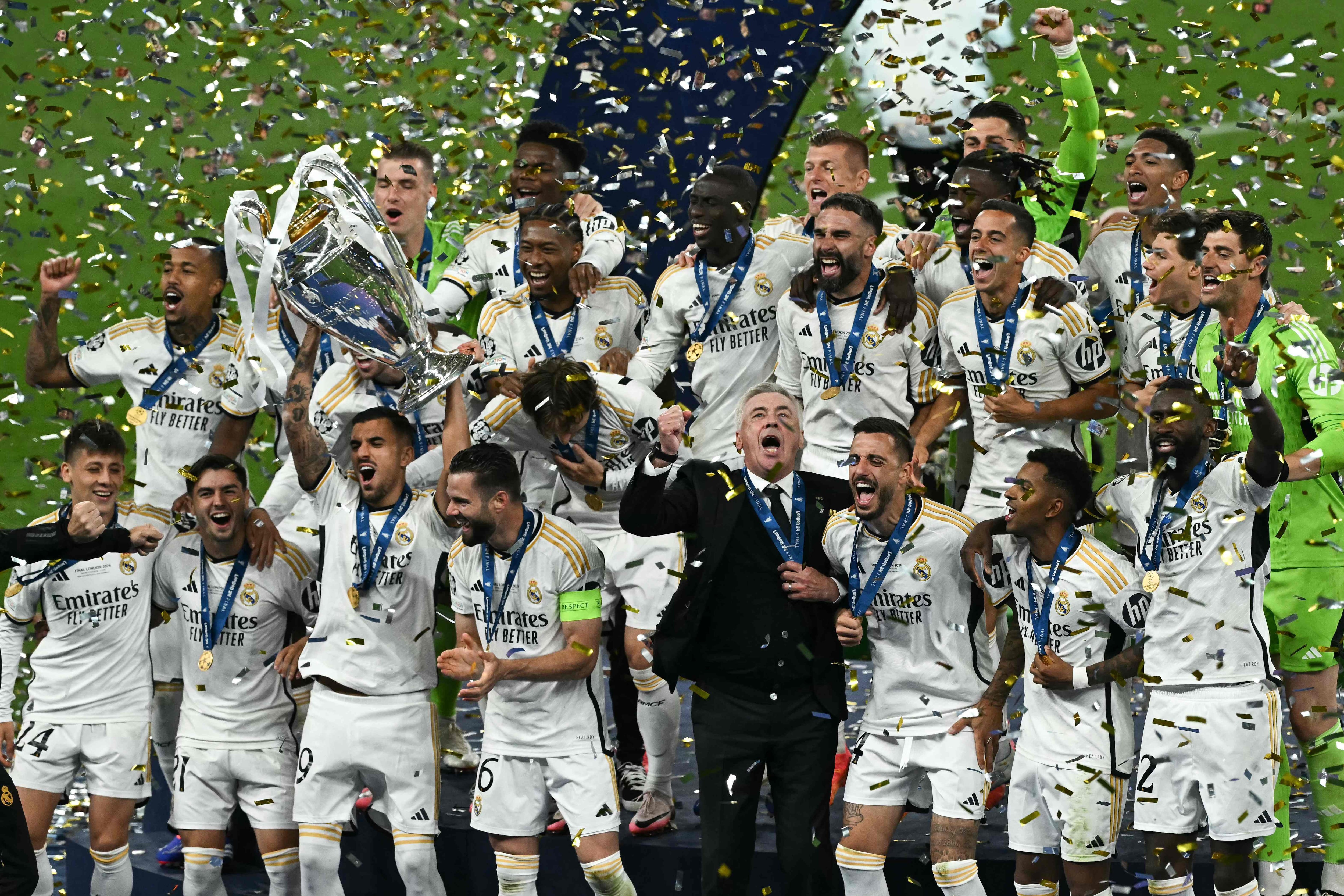 Real Madrid players celebrate with the trophy after the UEFA Champions League final football match between Borussia Dortmund and Real Madrid, at Wembley stadium, in London, on June 1, 2024. (Photo by Ben Stansall / AFP)