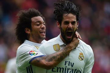 Real Madrid's midfielder Isco (R) is congratulated by teammate Brazilian defender Marcelo after scoring a goal during the Spanish league football match Real Sporting de Gijon vs Real Madrid CF at El Molinon stadium in Gijon on April 15, 2017. / AFP PHOTO 