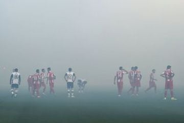 Players wait for the smoke disperses from the pitch after supporters burnt torches during the Serbian National soccer league derby match between Partizan and Red Star, in Belgrade on February 27, 2016. Red Star won 1-2 at the 150th edition of the 'Eternal