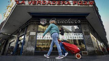 BUENOS AIRES, ARGENTINA - JULY 24:  People walk in front of the traditional pizza restaurant Banchero on July 24, 2020 in Buenos Aires, Argentina. Traditional pizza restaurants of the iconic Corrientes Avenue in the Theater District struggle to survive during the government-ordered lockdown to curb spread of COVID-19. Since March 20, they can only work with delivery and take away, which in most cases represents a significant drop in their sales. Unable to adapt or be profitable, some pizzerias opted to remain closed until situation comes back to normal while others had to close down definitively. (Photo by Marcelo Endelli/Getty Images)