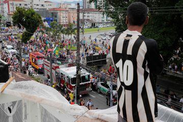 A fan of the late Brazilian football star Pele observes from a roof as a firetruck transports Pele's coffin to the Santos' Memorial Cemetery in Santos, Sao Paulo state, Brazil on January 3, 2023.