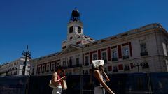 A woman covers her head with a bag as she walks at Puerta del Sol square during a hot day as Spain braces for a heatwave in Madrid, Spain, June 10, 2022. REUTERS/Susana Vera