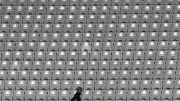 A man walks past empty stands during a training session of Denmark&#039;s national football team on June 1, 2021 in Innsbruck, Austria, on the eve of a friendly football match of Denmark against Germany, in preparation of the 2020 / 2021 UEFA European Cha