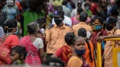 A security personnel (C) checks the body temperature of a woman (C-L) as she enters a market among a crowd of people as a preventive measure against the spread of the COVID-19 coronavirus in Chennai on July 29, 2020. (Photo by Arun SANKAR / AFP)