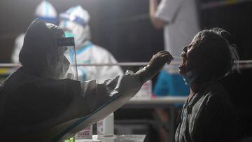This photo taken on August 11, 2021 shows a resident receiving a nucleic acid test for the Covid-19 coronavirus at a residental area which is restricted due to the virus in Wuhan, in China&#039;s central Hubei province. (Photo by STR / AFP) / China OUT