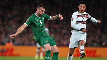 11 November 2021, Ireland, Dublin: Republic of Ireland&#039;s Shane Duffy (L) clears the ball under pressure from Portugal&#039;s Cristiano Ronaldo during the 2022 FIFA World Cup European Qualifiers Group A soccer match between Ireland and Portugal at the