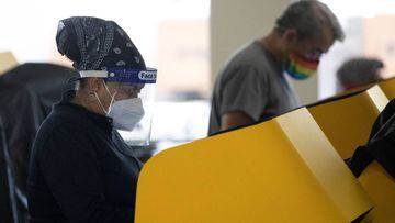 Angela Whitney wears a face shield and a face protective mask as she votes in the U.S. presidential election in the Jurassic Parking structure at Universal Studios Hollywood during the outbreak of the coronavirus disease (COVID-19), in Universal City, Cal