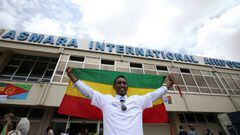 A passenger holds the Ethiopian national flag as he celebrates after arriving at the Asmara International Airport aboard an Ethiopian Airlines flight in Asmara, Eritrea July 18, 2018. REUTERS/Tiksa Negeri