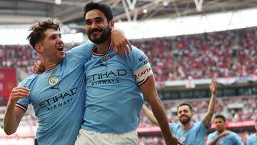 Manchester City's English defender John Stones (L) congratulates Manchester City's German midfielder Ilkay Gundogan after the second goal during the English FA Cup final football match between Manchester City and Manchester United at Wembley stadium, in London, on June 3, 2023. (Photo by Adrian DENNIS / AFP) / NOT FOR MARKETING OR ADVERTISING USE / RESTRICTED TO EDITORIAL USE