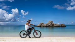 Ayato Kimura con su bici de MTB Downhill en una playa de Okinawa (Japón).